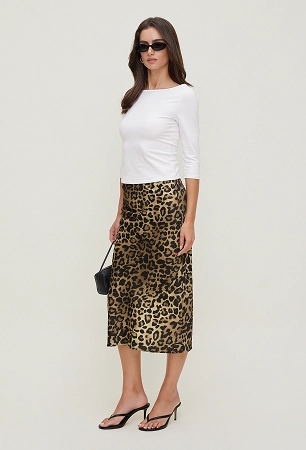 Model is wearing a white 3/4 sleeve top and a leopard print midi skirt.