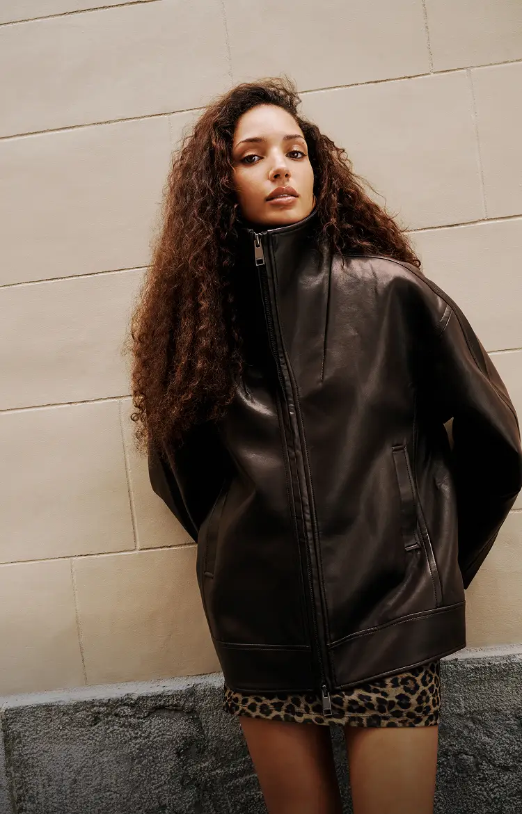 Model is wearing a brown faux leather cocoon jacket and a leopard print mini dress.