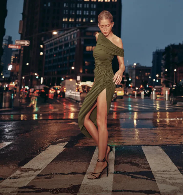 Model is wearing a khaki asymmetrical midi dress.