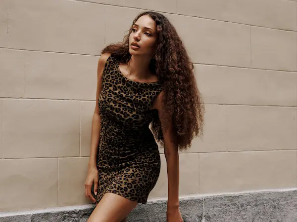 La mannequin porte une minirobe brune à motif léopard.